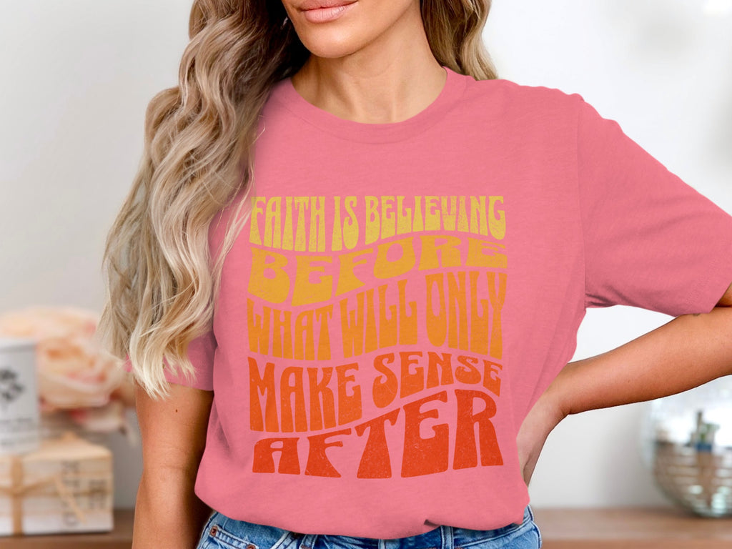 Pink t-shirt with yellow and orange text "Faith is believing before what will only make sense after".