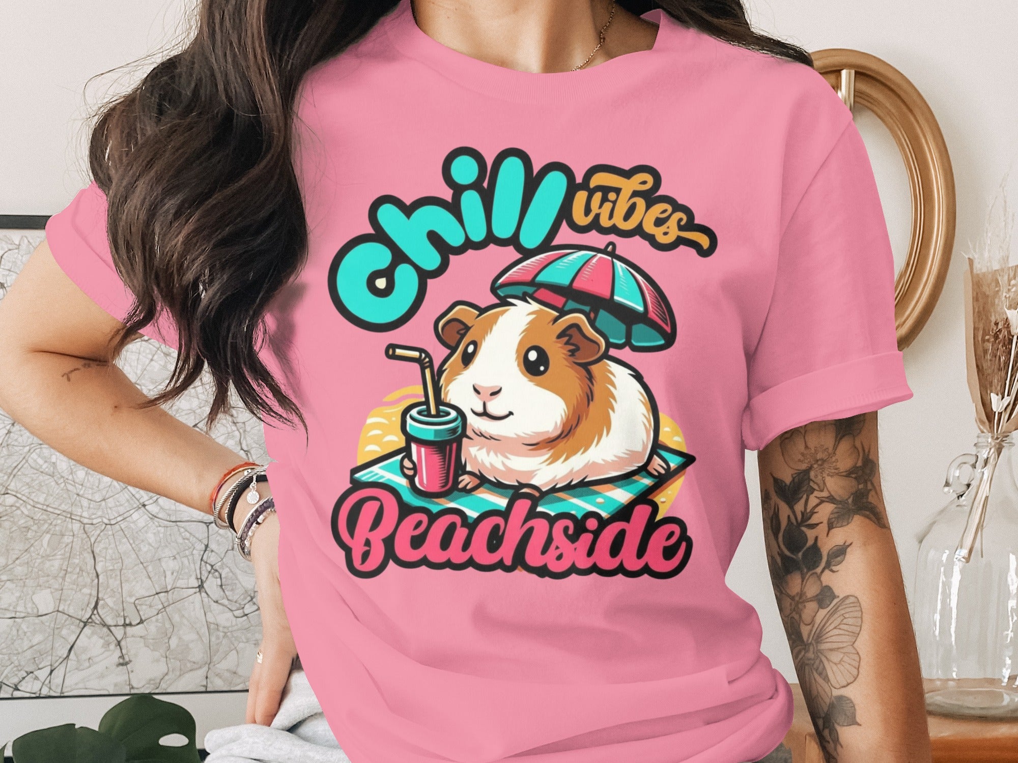 Guinea pig on a beach towel with a drink under an umbrella, text "Chill Vibes Beachside".